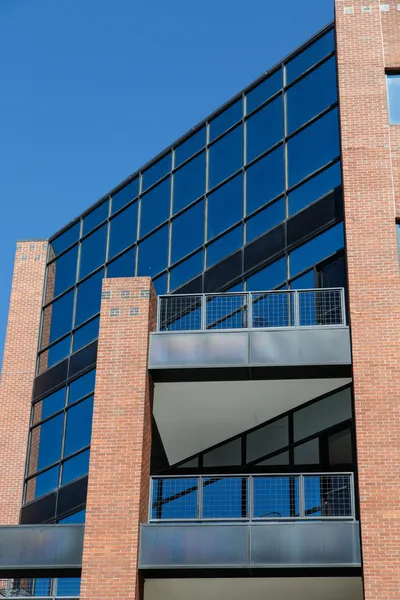 Torre de oficina de cristal azul con columnas de ladrillo rojo —  Fotos de Stock