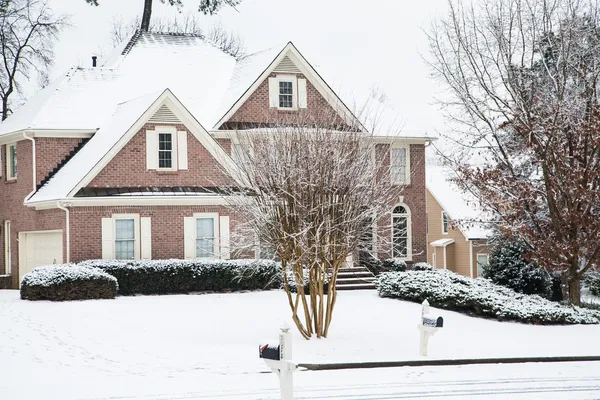 れんが造りの家と雪の中で芝生 — ストック写真