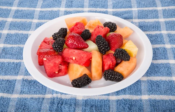Placa branca de frutas e bagas frescas cortadas — Fotografia de Stock