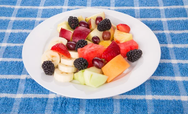 Teller mit frischem Schnitt und ganzen Früchten — Stockfoto