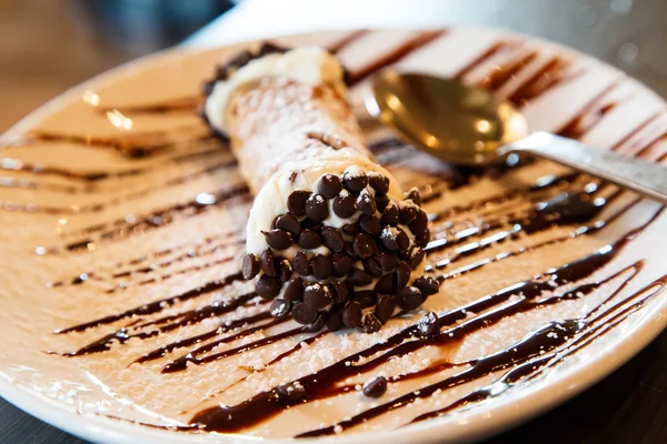 Cannoli em uma placa com molho de chocolate — Fotografia de Stock