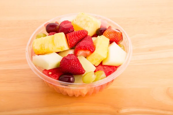 Frutas frescas cortadas em tigela de plástico — Fotografia de Stock