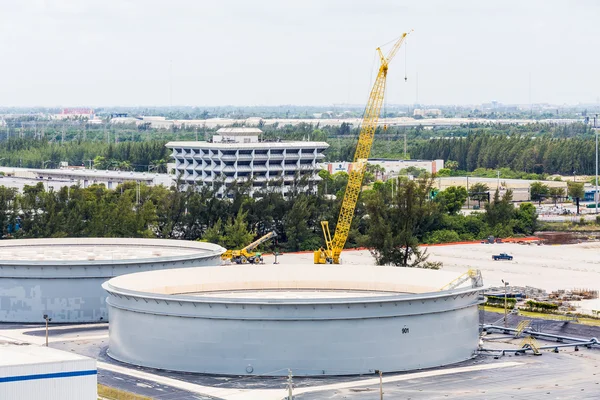 Réservoirs de béton et grue jaune — Photo