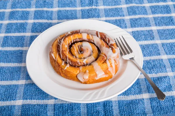 Cinmon Roll on White Plate on Blue Towel — Stock Photo, Image
