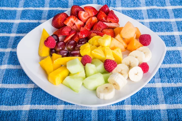 Geschnitten und in Scheiben geschnitten Obst auf einem quadratischen weißen Teller — Stockfoto