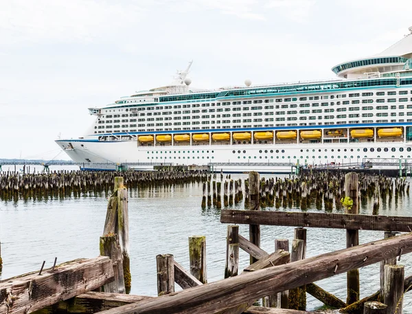 Gele reddingsboten op cruiseschip verleden houten palen — Stockfoto