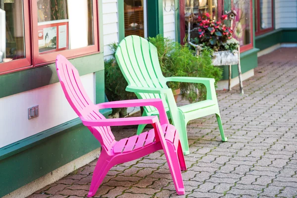 Cadeiras rosa e verde na calçada da cidade — Fotografia de Stock