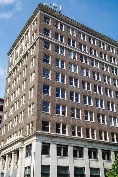 Antiguo edificio de ladrillo cuadrado bajo cielos azules — Foto de Stock