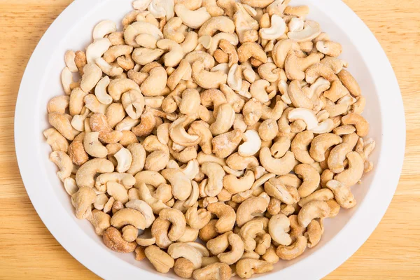 Gezouten geroosterde cashewnoten in witte plaat — Stockfoto