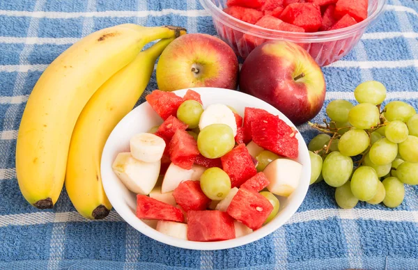 Ganze Früchte mit geschnittenen Früchten in Schüssel — Stockfoto