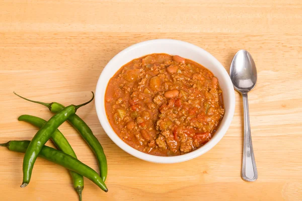 Skål med chili med paprika och sked — Stockfoto