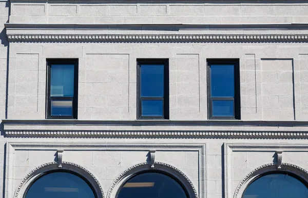 Гранитное здание с голубыми окнами — стоковое фото