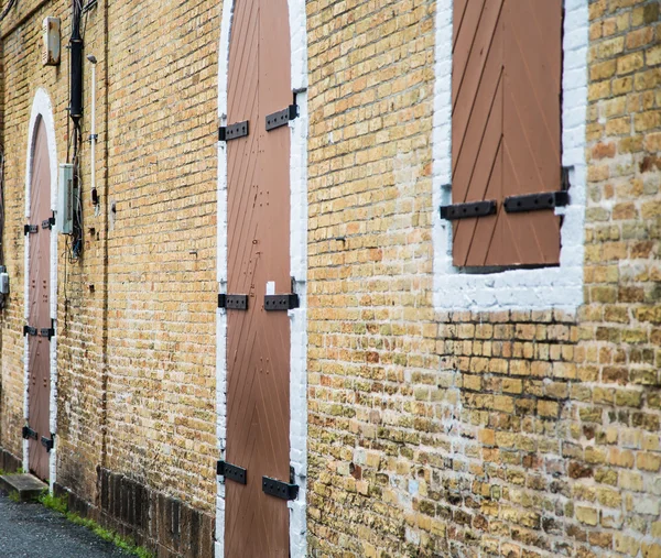 Hout en ijzer ramen en deuren in bakstenen muur — Stockfoto