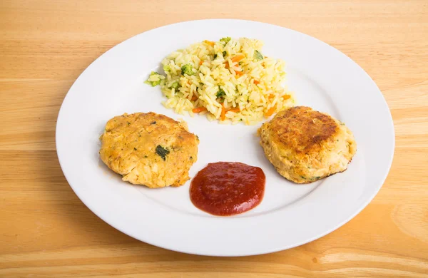 Zwei Krabbenkuchen mit käsigem Brokkoli-Reis — Stockfoto