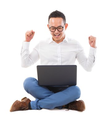 Excited Asian man using laptop clipart
