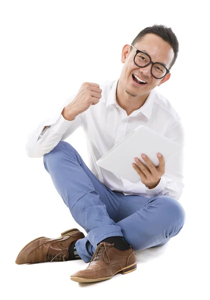 Asian man sitting on floor using tablet — Stock Photo, Image