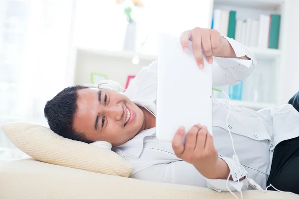 Asiático hombre escuchar canción en sofá — Foto de Stock