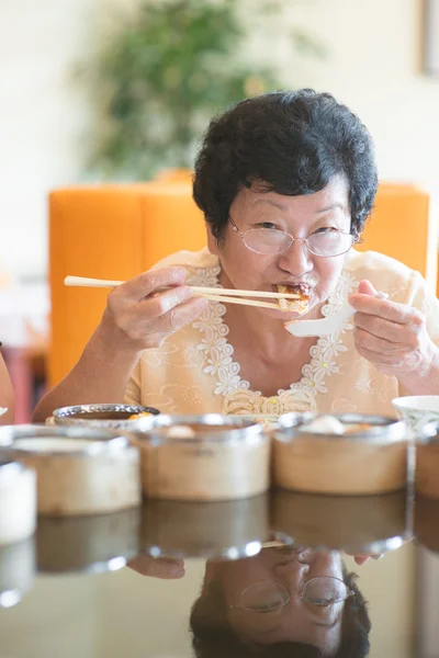 레스토랑에서 식사 하는 수석 아시아 여자 — 스톡 사진