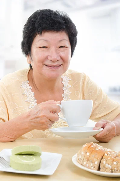 Asyalı kadın kıdemli having kahvaltı — Stok fotoğraf