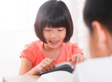 Asyalı çocuk evde kitap okurken