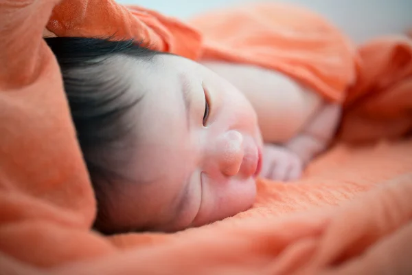Newborn Asian baby girl on bed Stock Picture