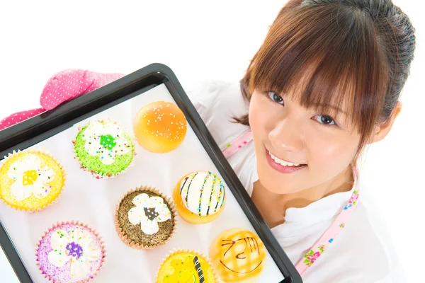 Young Asian woman baking bread and cupcakes — Stock Photo, Image