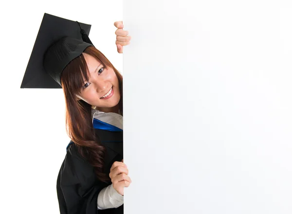 Estudante graduado escondido atrás de cartaz em branco — Fotografia de Stock