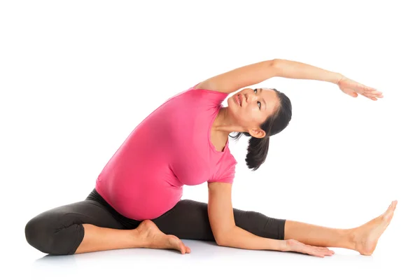 Pregnant woman yoga position seated side stretch. — Stock Photo, Image