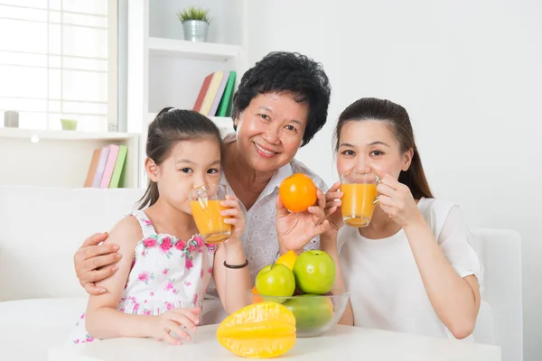 Asian family drinking orange juice. — Stock Photo, Image