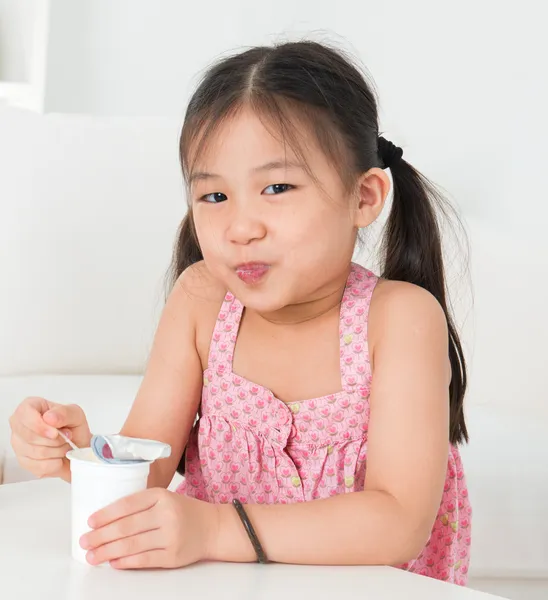 Asian kid eating yoghurt — Stock Photo, Image