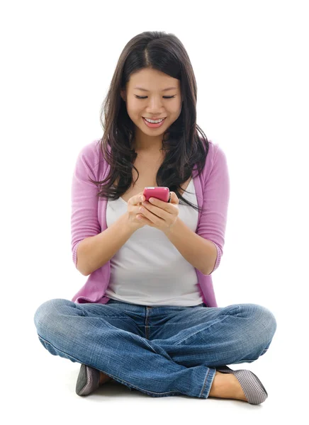 Mulher jovem mensagens de texto no telefone inteligente — Fotografia de Stock