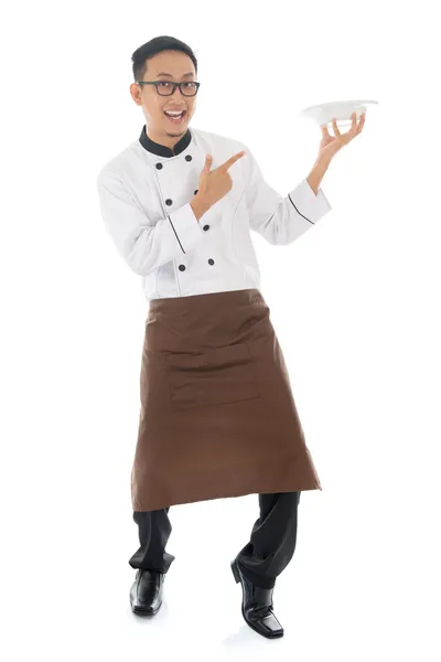 Aziatische mannelijke chef-kok wijzen een lege plaat — Stockfoto