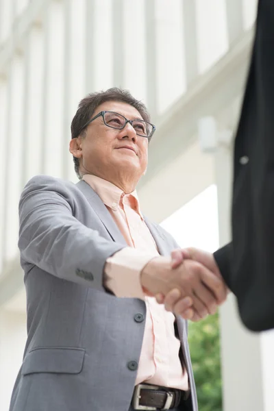 Asiáticos empresários handshaking — Fotografia de Stock