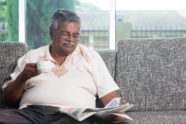 Indischer Senior trinkt Kaffee während er Zeitung liest — Stockfoto