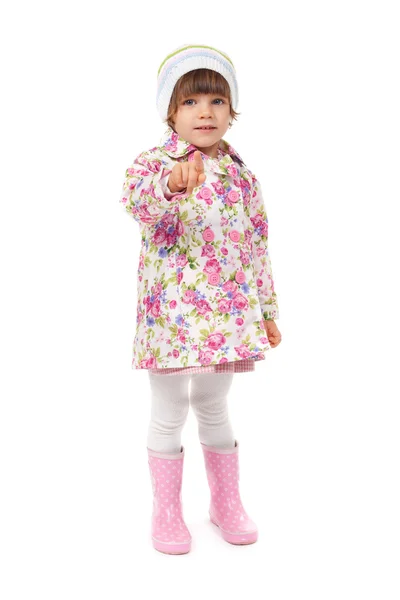 Little girl in boots and a jacket shows finger — Stock Photo, Image