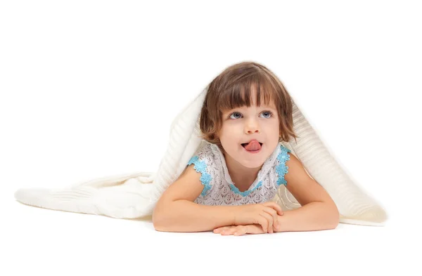 Little girl lying on the floor wrapped in a light blanket and to — Stock Photo, Image