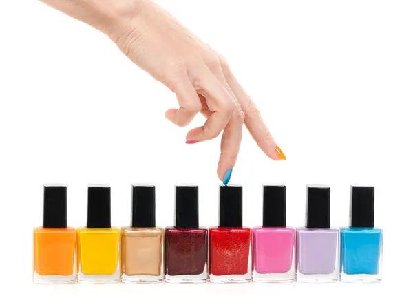 Female hand fingers are the colored paints polish on a white bac — Stock Photo, Image