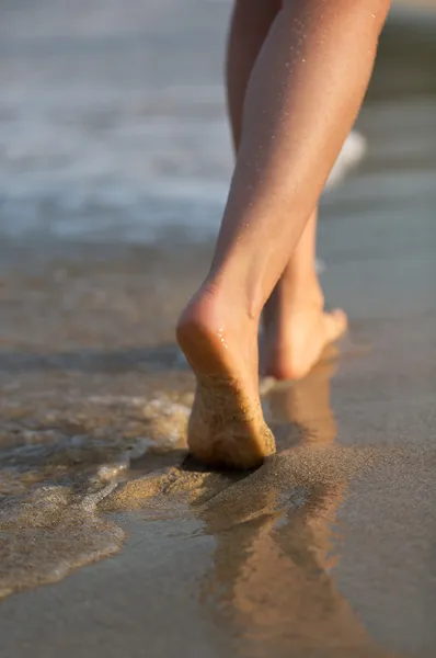Όμορφη γυναίκα πόδια στην παραλία στο ηλιοβασίλεμα — Φωτογραφία Αρχείου