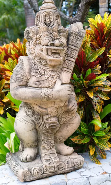 Thai stone god in the bushes of tropical plants — Stock Photo, Image