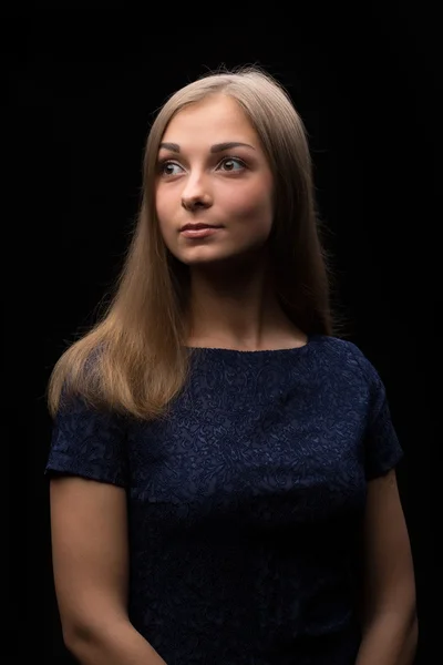 Porträtt av en vacker flicka på en svart bakgrund — Stockfoto