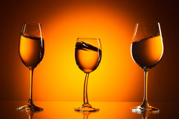 Trzy szklanki na pomarańczowym tle — Zdjęcie stockowe