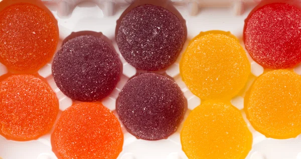 Round jelly sprinkled with sugar in a plastic box. — Stock Photo, Image