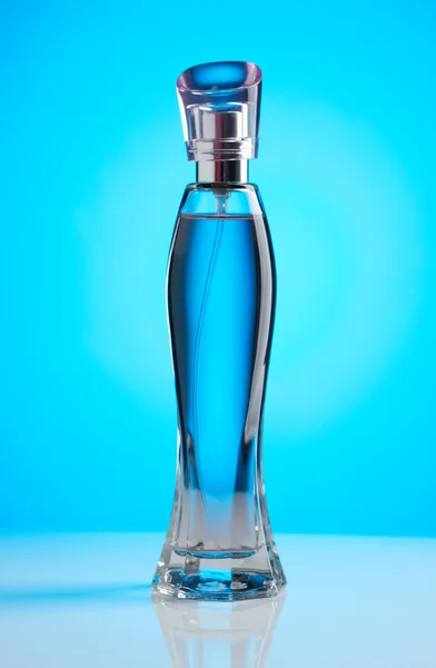 Women's perfume bottle on a blue background — Stock Photo, Image