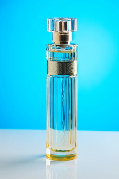 Zylindrische Parfümflasche auf blauem Hintergrund. — Stockfoto