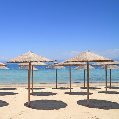Deniz kenarında hasır şemsiyeler
