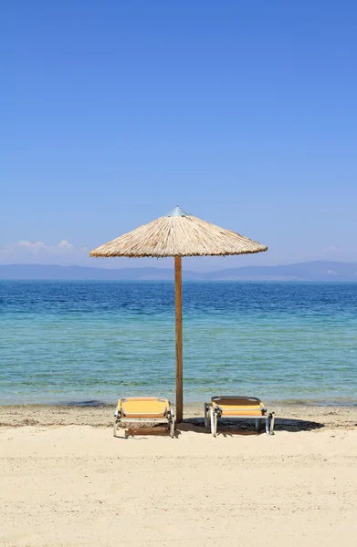 Umbrellas and recliners by the sea — Stock Photo, Image