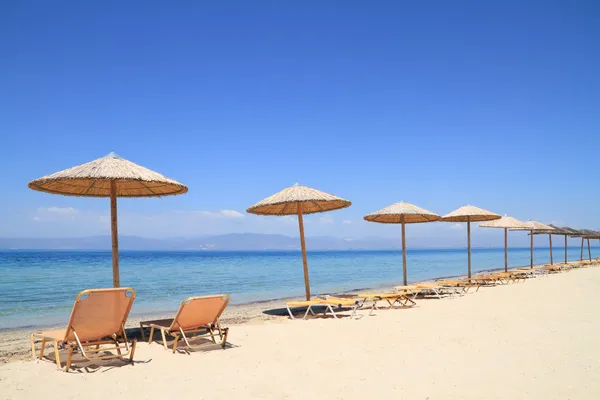 Umbrellas and recliners by the sea — Stock Photo, Image