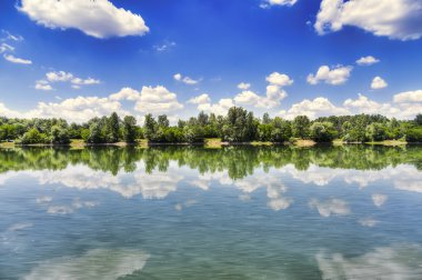 Gölün yüzeyinde yansıtan bulutlar