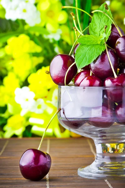 Frutas de cereza dulce en copa de vidrio con hoja de menta —  Fotos de Stock