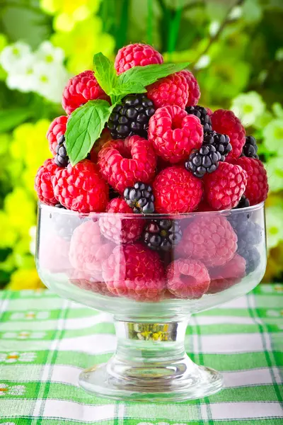 Dulces frutas frescas en copa de vidrio con hoja de menta — Foto de Stock